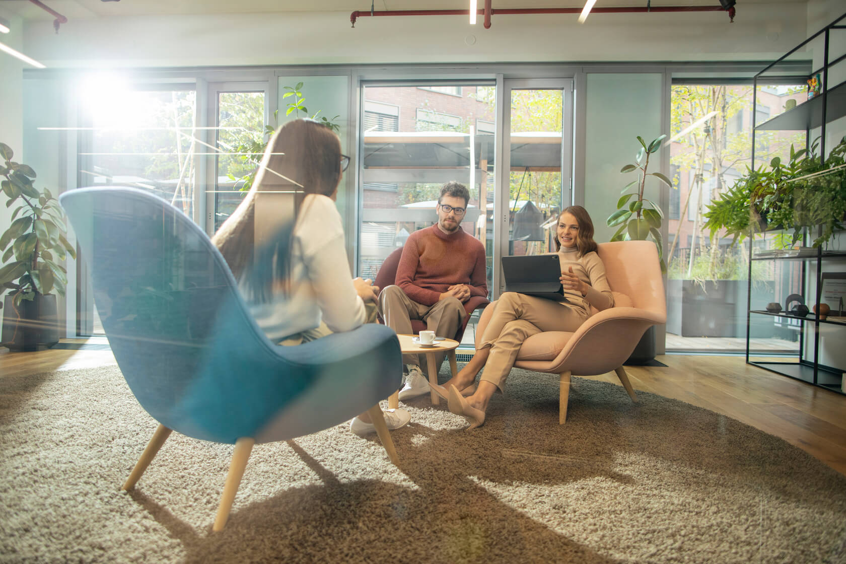 Workspace consultants and a client sitting on armchairs in a lobby talking about office fit out.