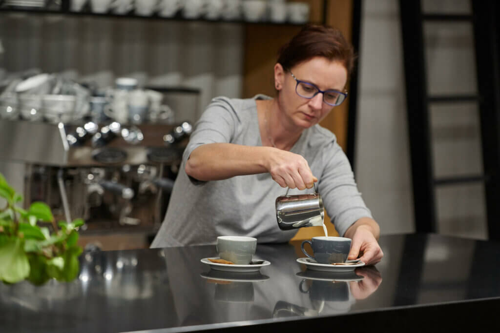 A person mindfully preparing a coffee in a company with healthy eating culture.